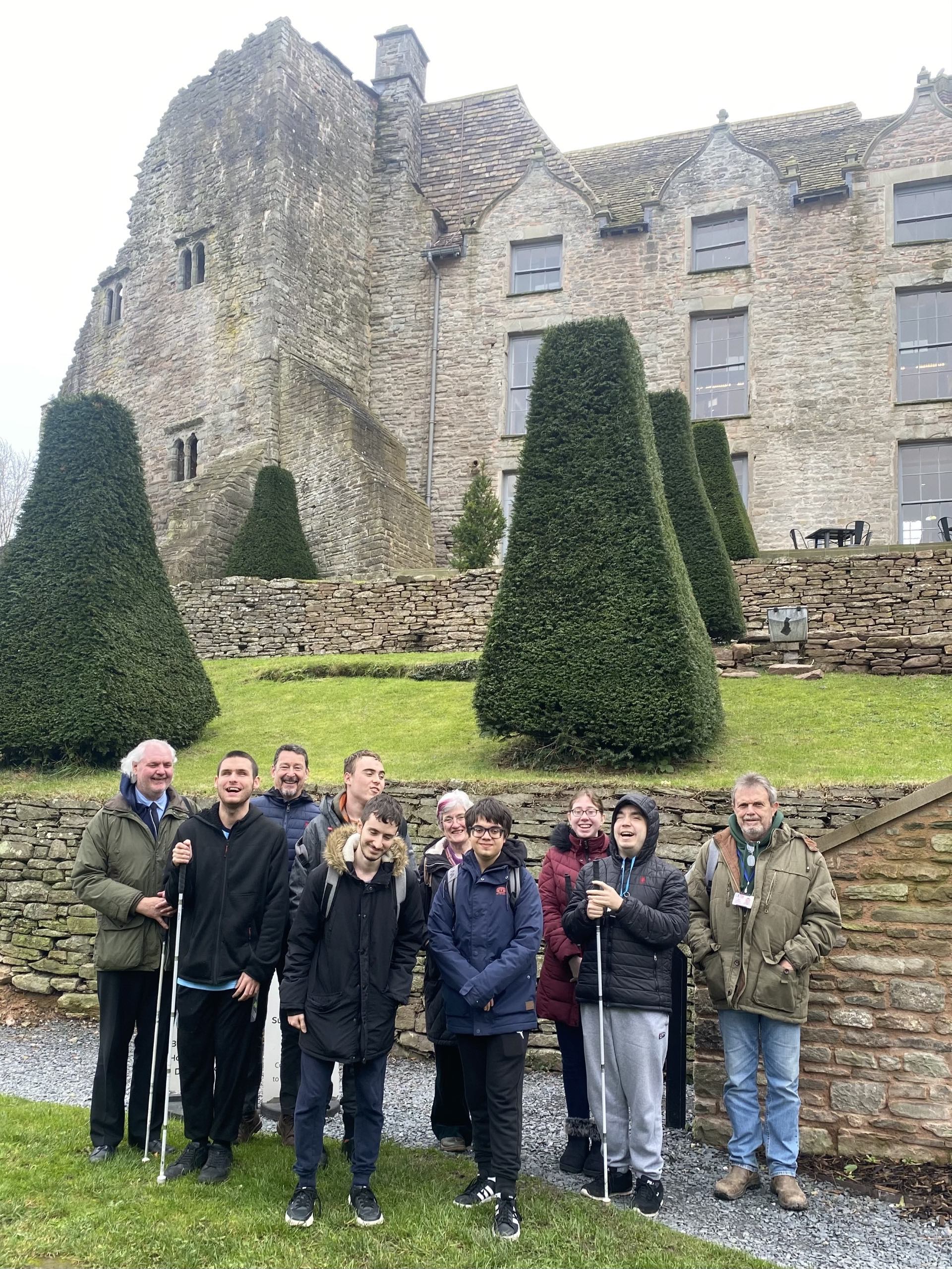 A group of business students, staff and volunteers stand in front of Hay Castle