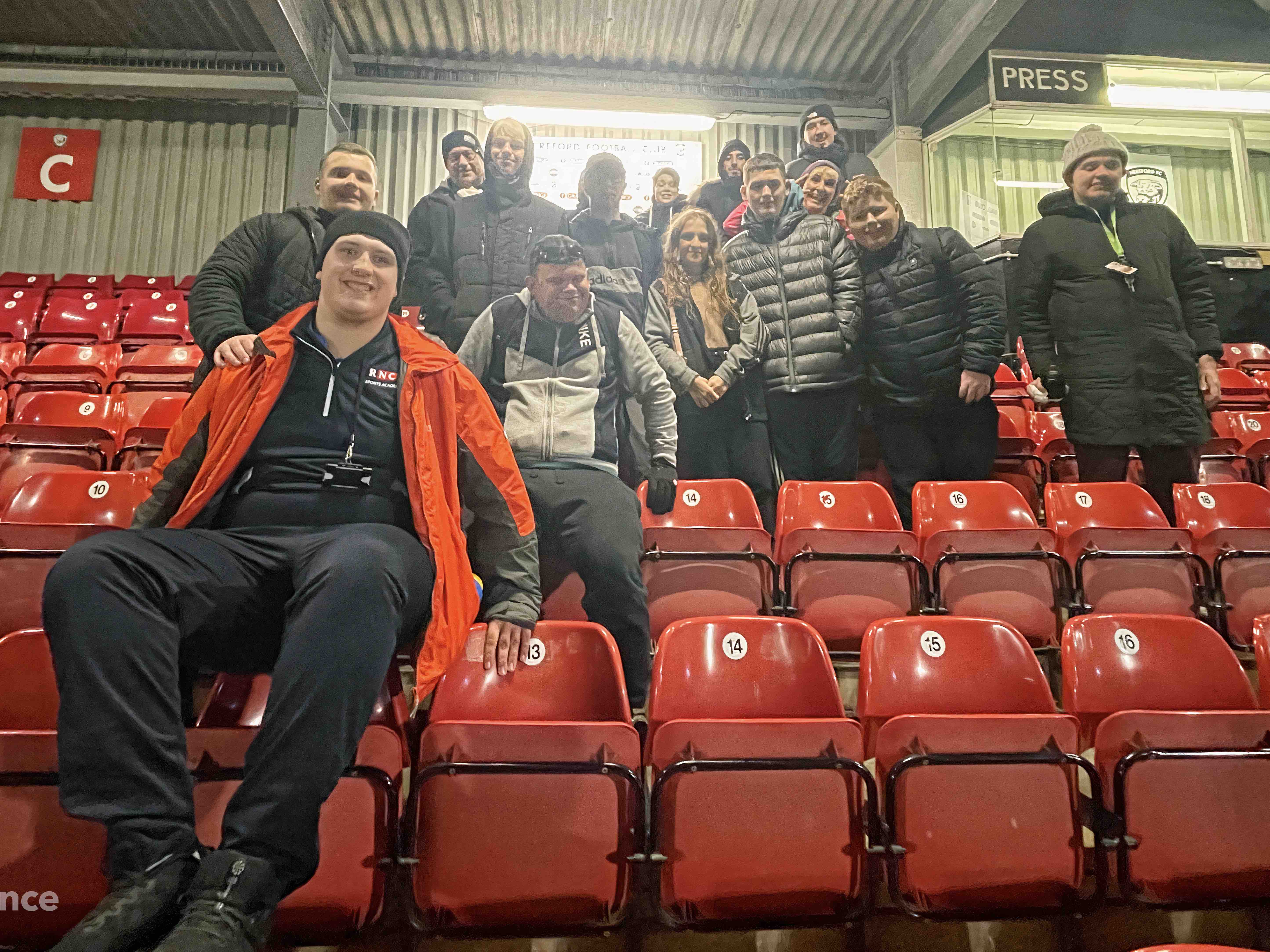 A group of staff and students in the stand at Hereford Football Club after watching the match