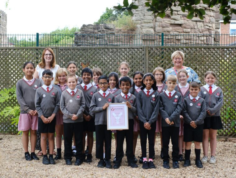The Class 4 pupils join their teacher and RNC's fundraising manager for a group photo. Two pupils at the front proudly display their framed Young Leader Award