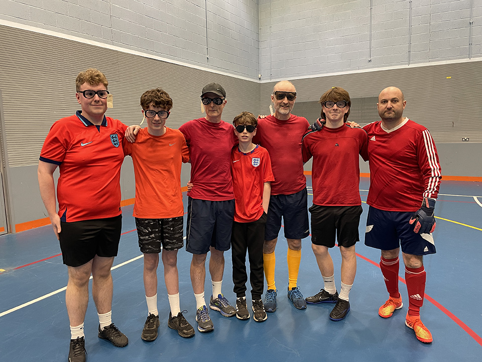 The Red Team standing in a row, each wearing a pair of sim specs apart from the goalkeeper on the end