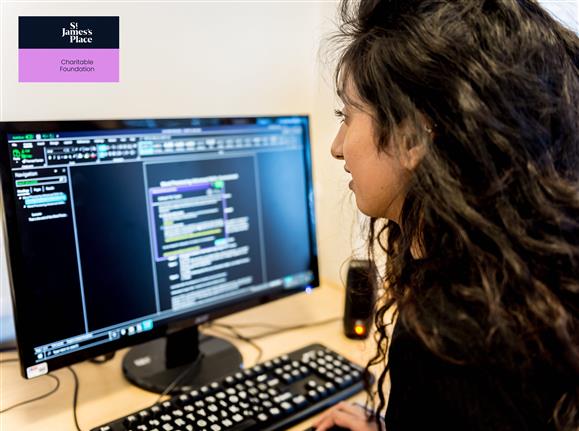 A student using accessible software on her computer, the St James Place Charitable Foundation logo is also positioned in the top left